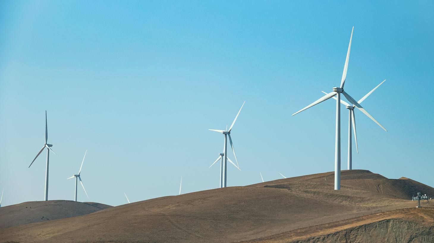 Image of a windmill plant with a rainbow above it